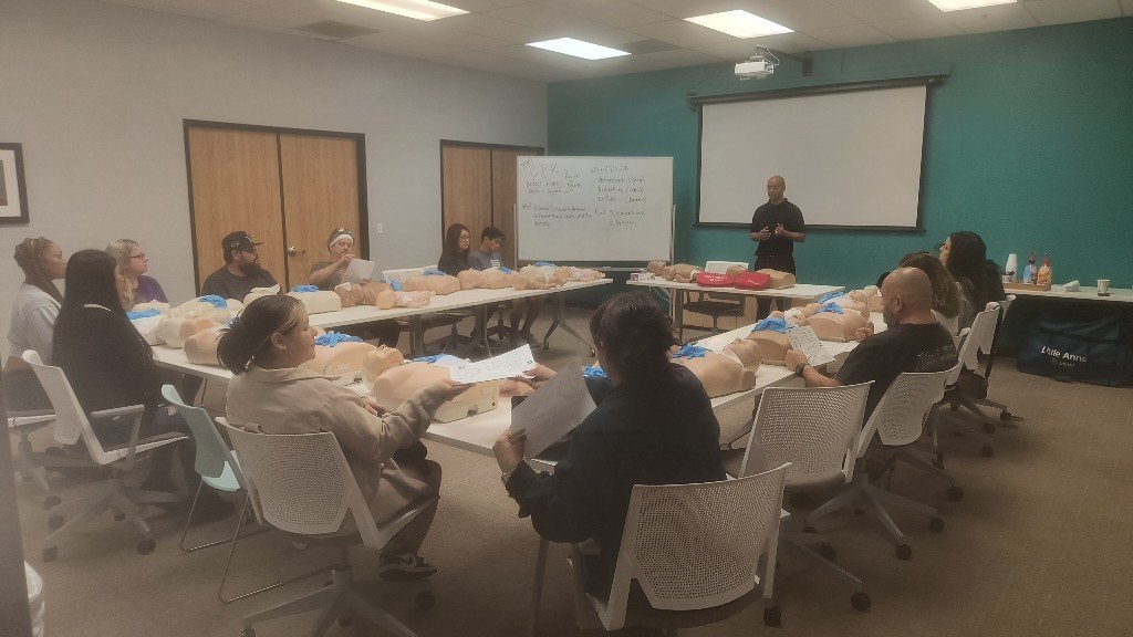 Christopher Garrett teaching a CPR class with hands-on manikins