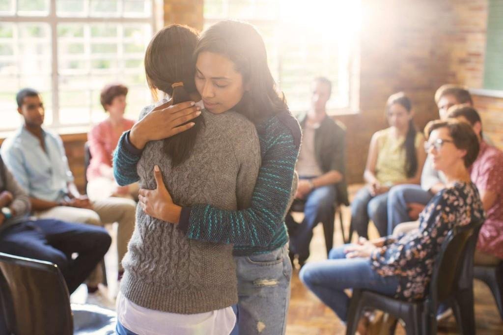 Support group members offering encouragement during substance abuse counseling